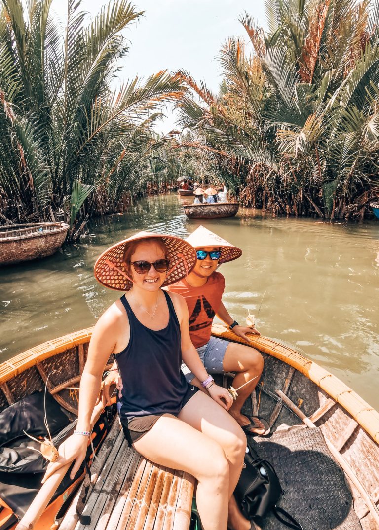 Helen and Andy with Vietnamese hats on floating on a bamboo basket boat through Bay Mau, best things to do in Hoi An