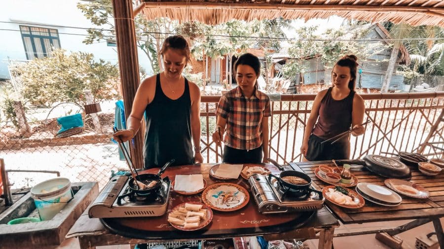 Helen deep frying spring rolls with chopsticks at a cookery class, one of the top things to do in Hoi An, Vietnam