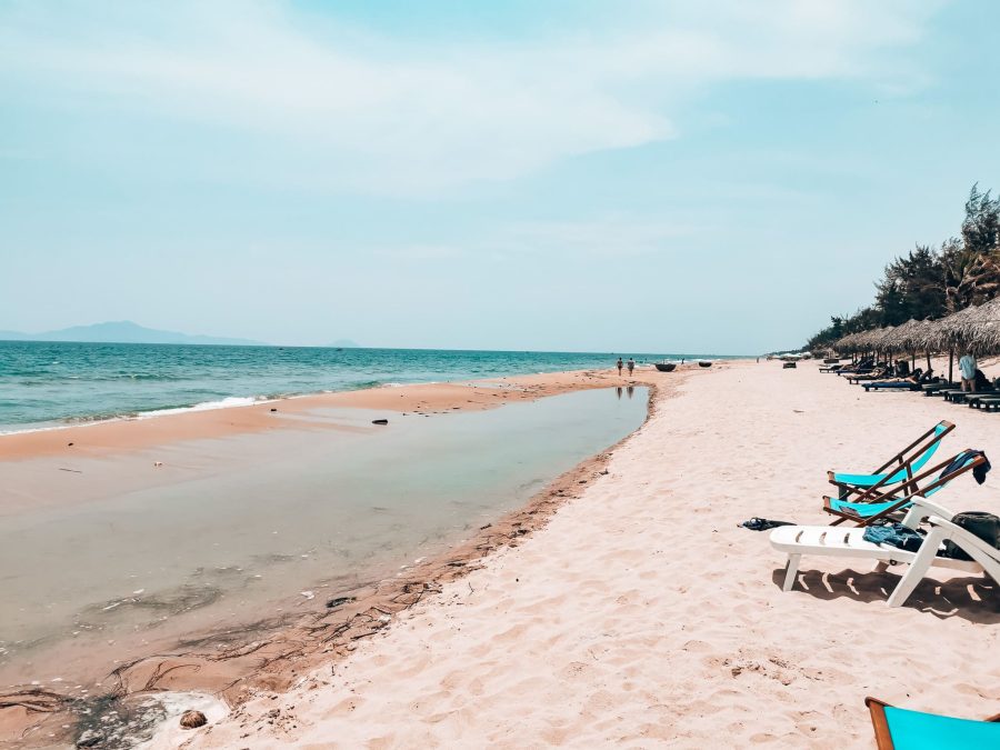 A long stretch of white sand with deck chairs on, Hidden Beach, places to visit in Hoi An