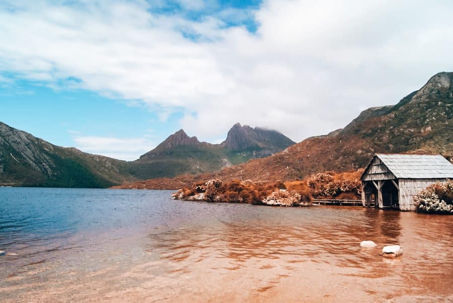 A beautiful and lonely boat shed on the shores of Dove Lake in the shadows of the peaks of Cradle Mountain, one of the most beautiful things to see in Tasmania