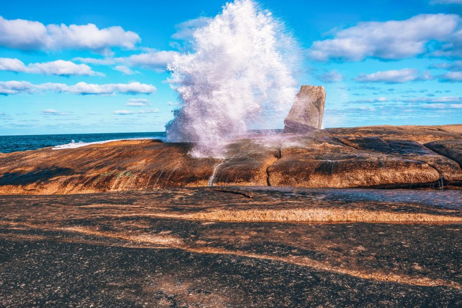 A large crashing of waves through the Bicheno Blowhole, Tasmania, Australia