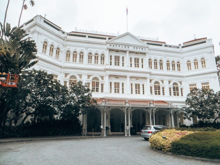 The beautiful and grand white exterior of Raffles Hotel is where to stay in Singapore if you're in the Civic District