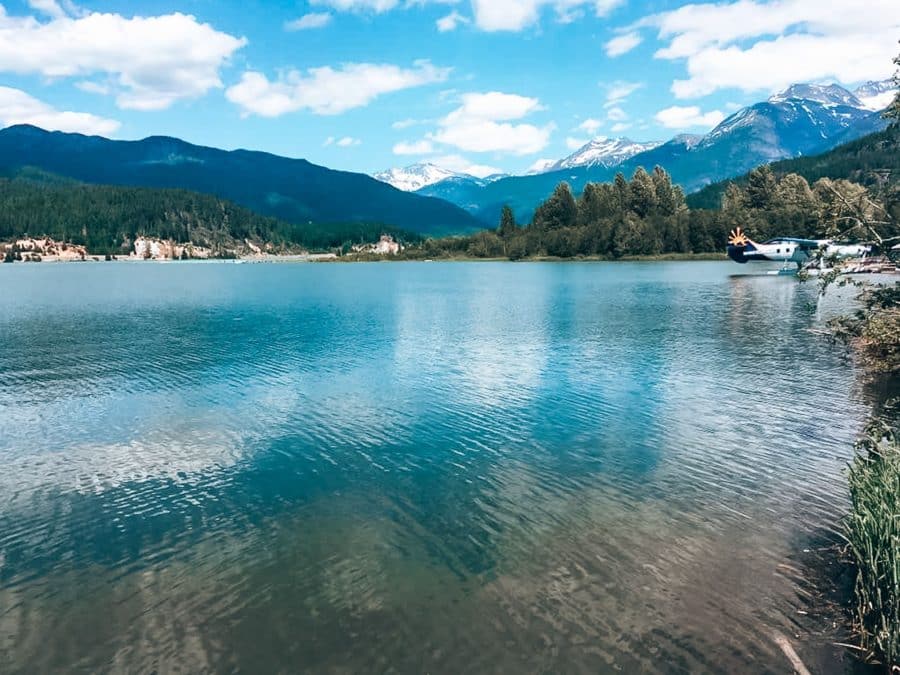 A float plane on Green Lake in Whistler in summer with mountains in the background, British Columbia, Canada