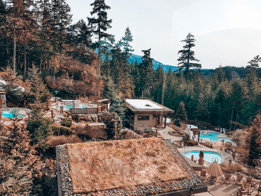 View over the Scandinave Spa's multiple pools and relaxation rooms with mountains in the background, Whistler, British Columbia, Canada