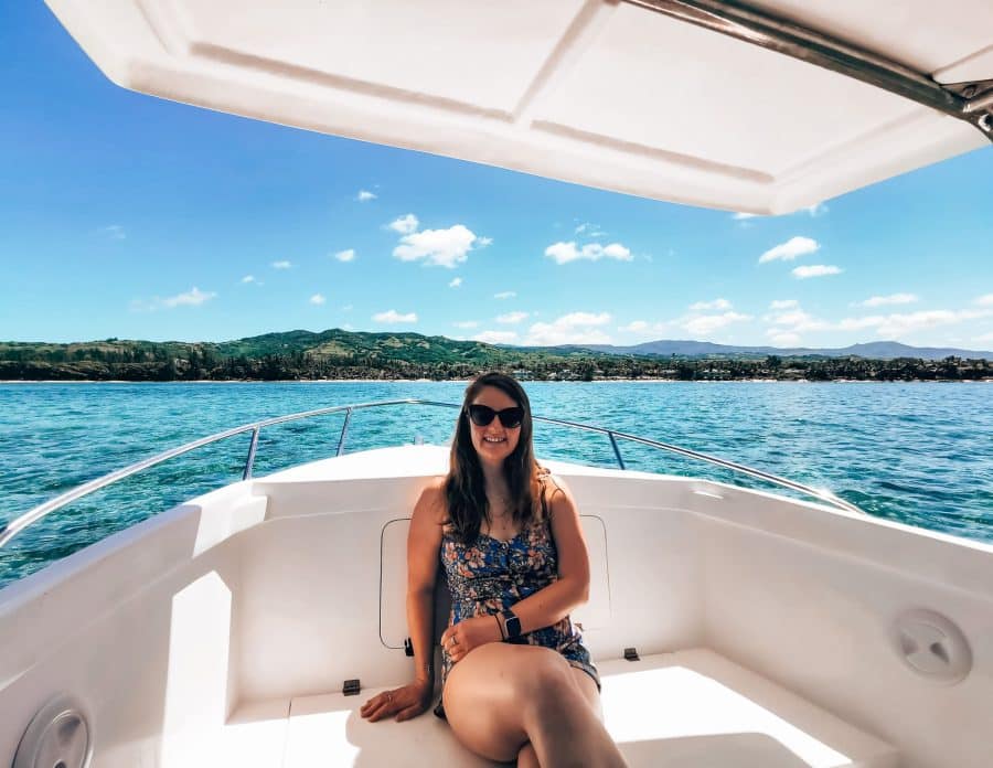 Helen on a boat at sea with the lush Mauritian countryside behind, Heritage Awali, Mauritius