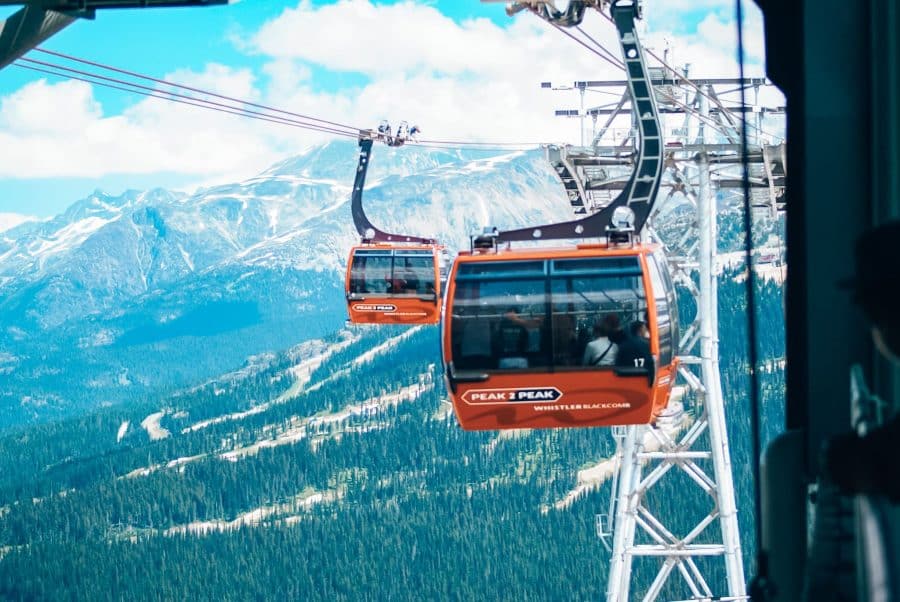 Two cable cars on the Peak 2 Peak Gondola with vast mountain ranges beyond, Whistler in summer, Canada, British Columbia