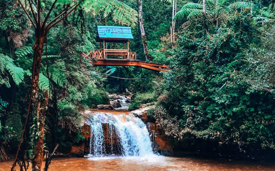 The tranquil Thompson Falls with a quaint picturesque red and blue bridge over them, Cameron Highlands, Malaysia