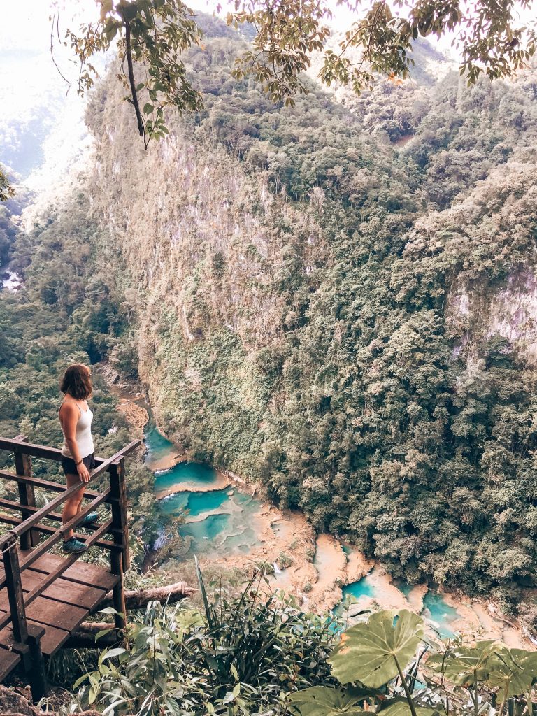 Helen looking down from the viewpoint over the striking turquoise pools nestled between towering limestone walls, Semuc Champey, Lanquin, Guatemala