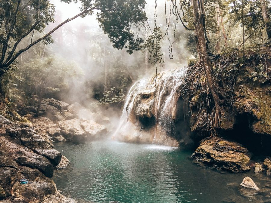 A steamy waterfall flowing into a pool below it surrounded by thick lush jungle, Finca el Paraiso is one of the best things to do in Guatemala, Rio Dulce