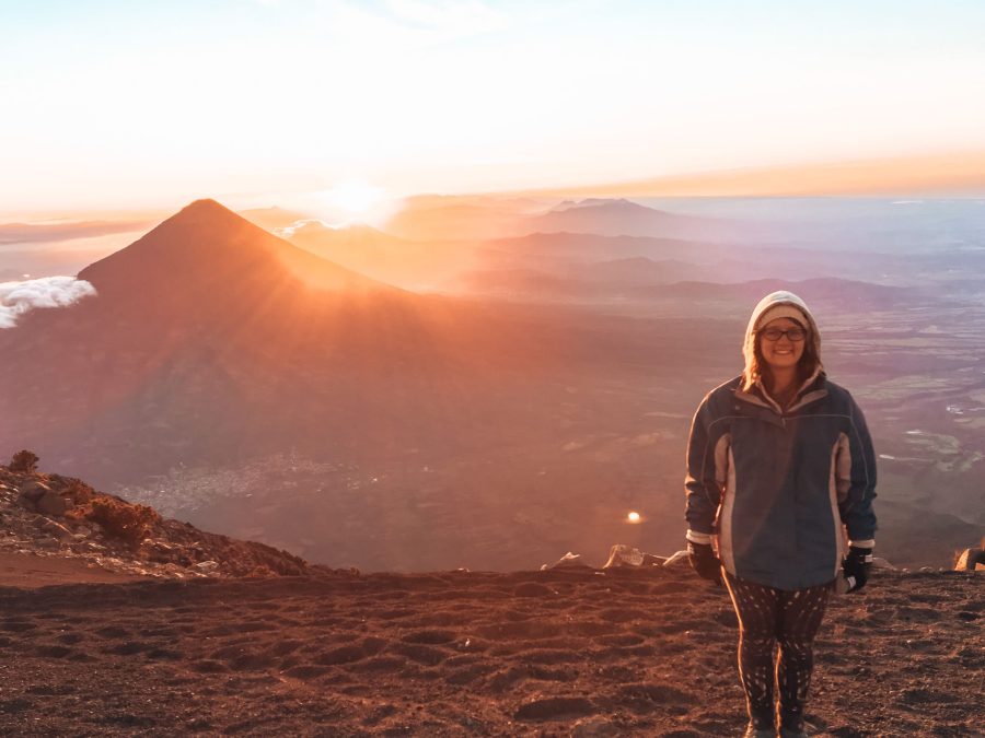 Helen stood on the summit of Volcan Acatenango with sunrise lighting up the volcanoes and mountains in the background, one of the most magnificent things to see in Guatemala