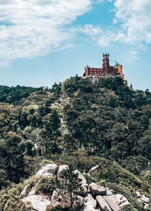 The flamboyant Pena Palace protruding through the lush thick trees, Sintra, Portugal