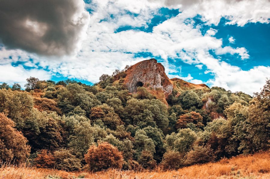 Thor's Cave from the Manifold Valley below protruding through the trees, one of the best things to do in the Peak District