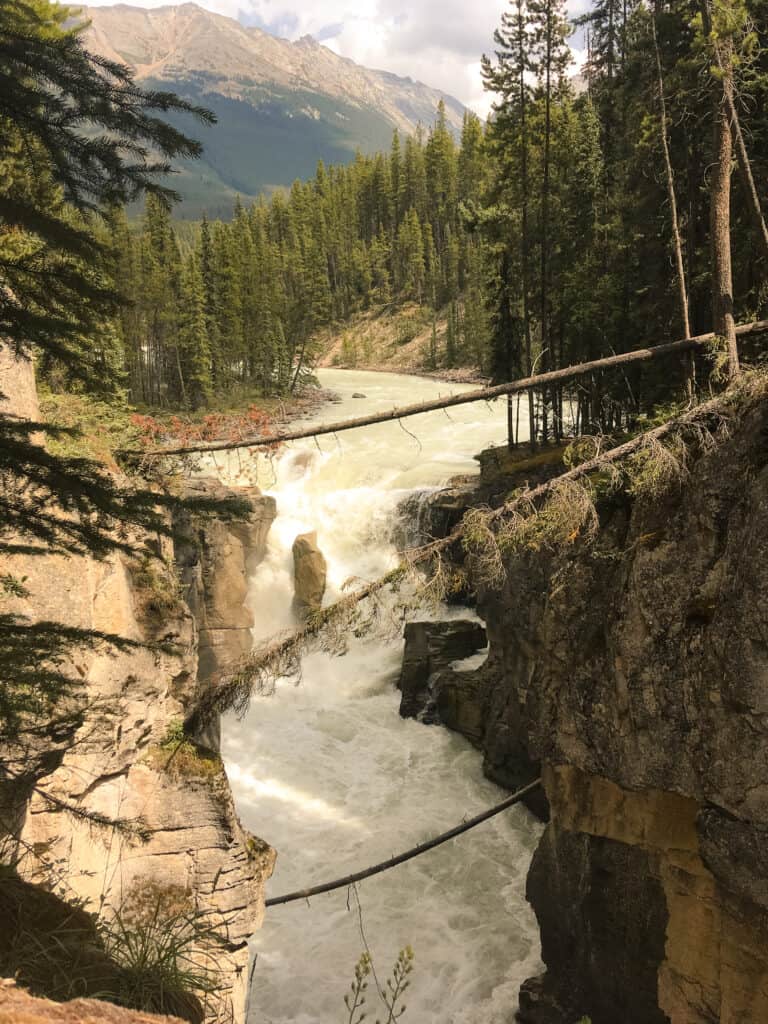 Sunwapta Falls with a dramatic nature background are a fantastic stop on the Icefield Parkway on your Calgary to Vancouver road trip