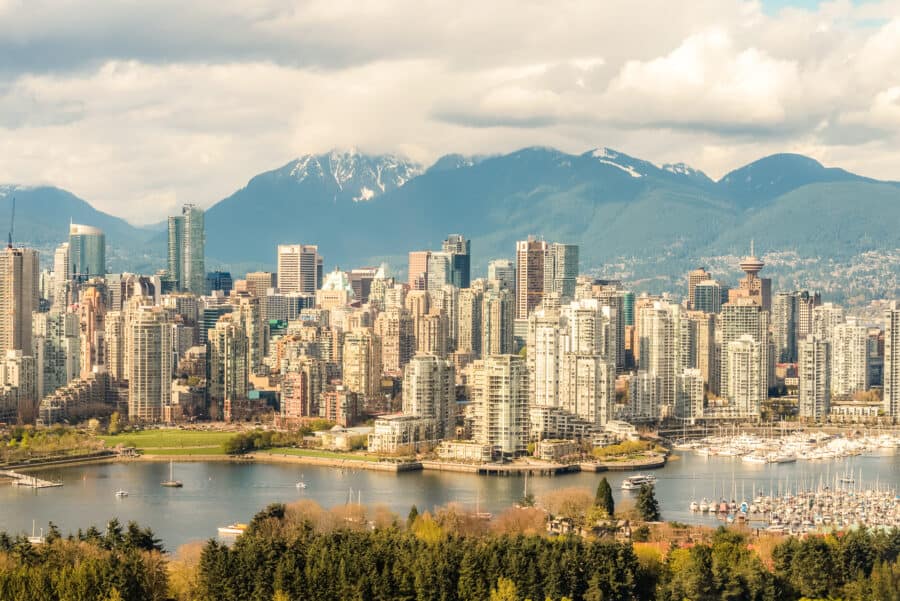 The imposing Vancouver skyline with dramatic mountain ranges behind, your last stop on your Calgary to Vancouver road trip