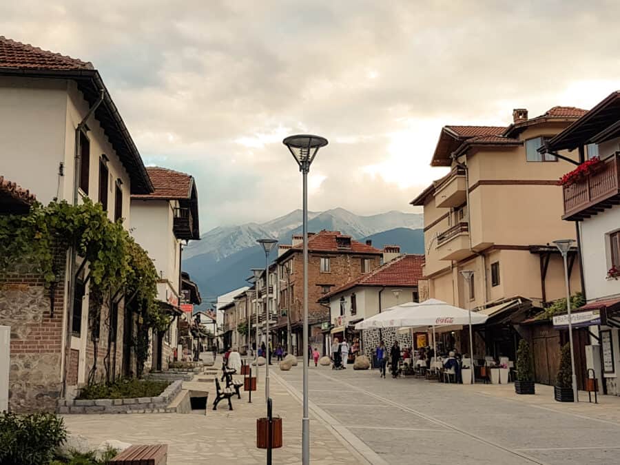 Bansko main street with a dramatic mountain backdrop should be on your list of places to visit in Bulgaria