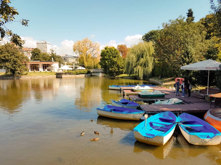 Tranquil lake with rowing boats on, surrounded by trees in Borisova Gradina, Sofia, Bulgaria