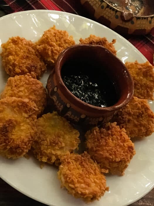 A plate of melted cheese coated in cornflakes with a pot of jam to dip in, Bulgaria