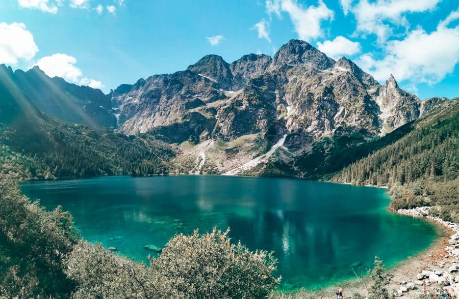 Shimmering alpine lake nestled underneath majestic peaks, Morskie Oko, hiking Rysy Mountain, Poland