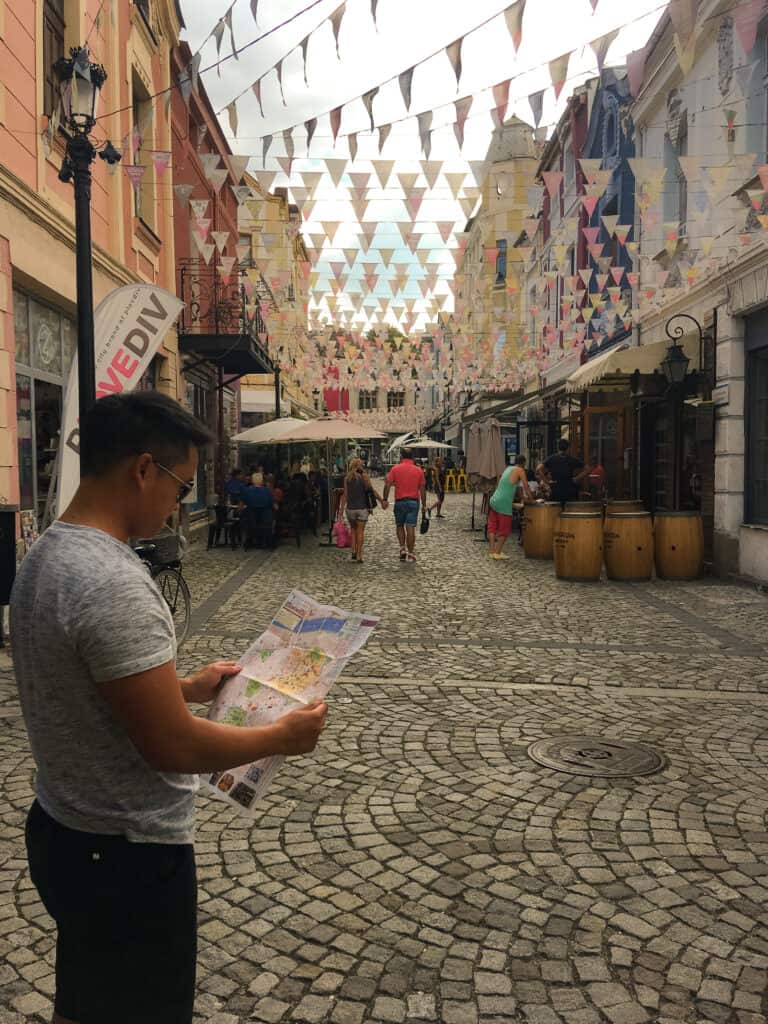 Andy looking at a map in the maze of flag-strewn cobbled streets in Plovdiv's Kapana, Bulgaria