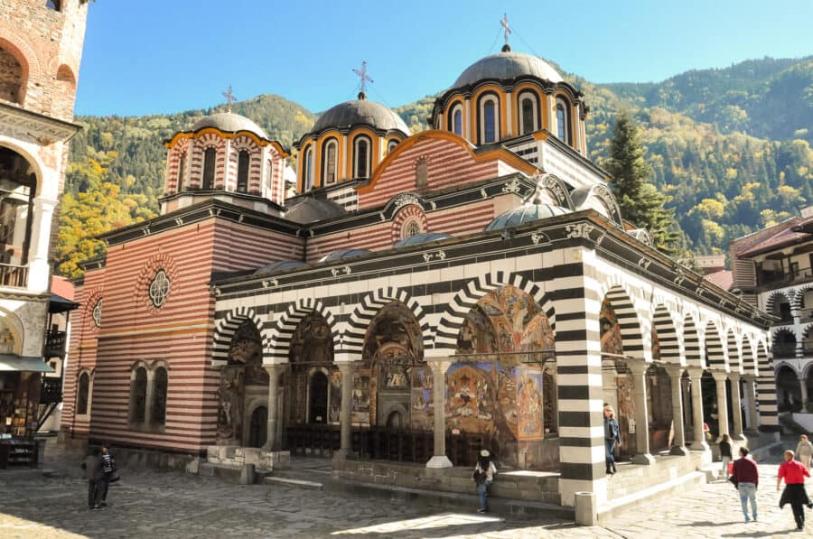 The red, black, white and gold beautifully coloured Rila Monastery with a spectacular mountain backdrop, is one of the top places to visit in Bulgaria