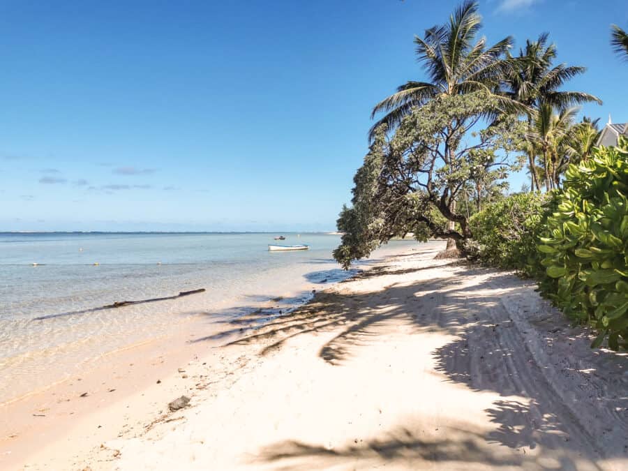 The wild and rugged south coast beach with pristine white sand and a shallow lagoon at the Heritage Awali, Mauritius