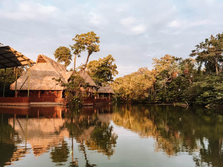 Thatched buildings on a river in the beautiful and tranquil Rio Dulce National Park amongst thick jungle, Guatemala