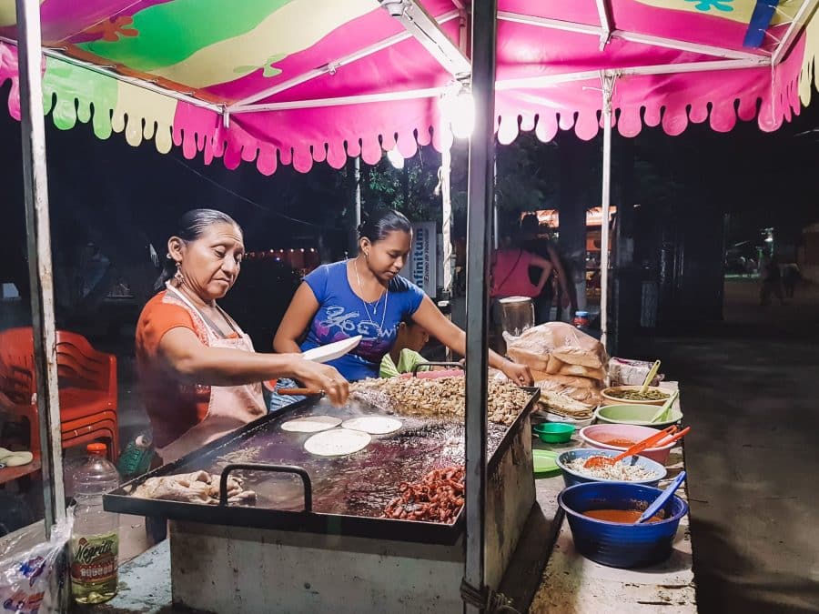 Two ladies at a colourful street food stall in Mexico City