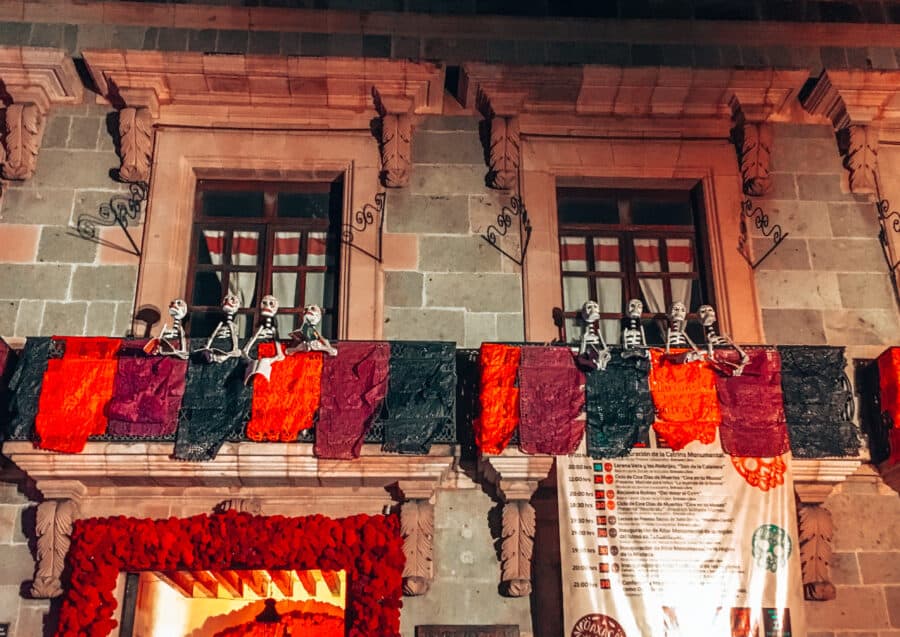 Skeletons hanging outside of windows in Oaxaca's streets during Day of the Dead, Mexico