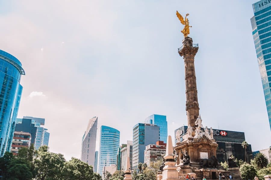 The imposing Angel de la Independencia with towering skyscrapers looming around it, Mexico City