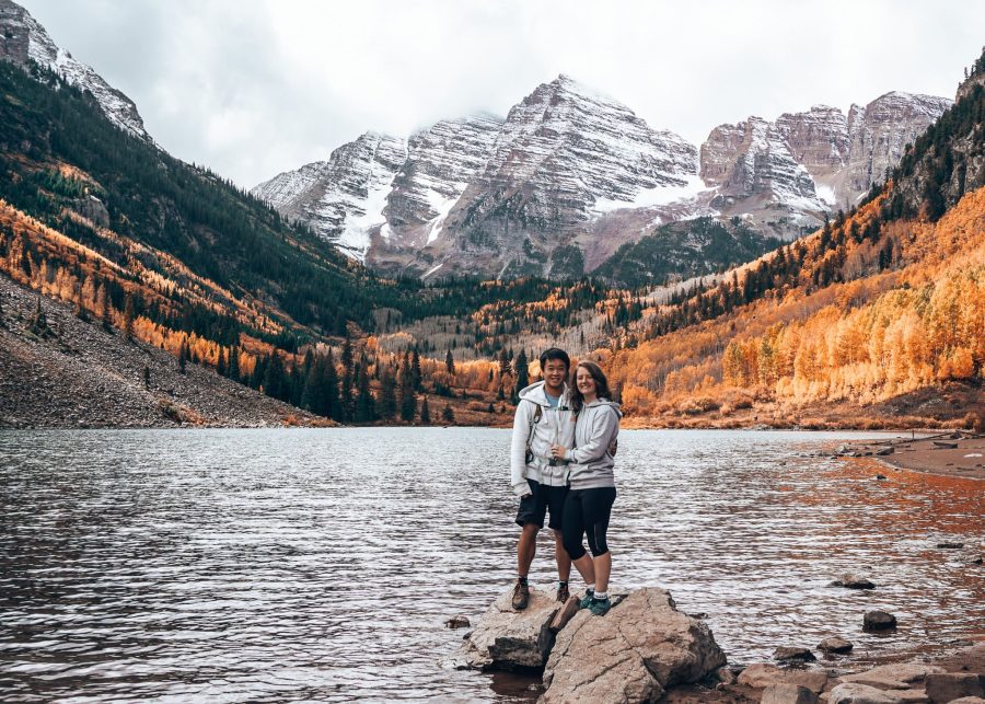 Helen and Andy stood on a rock on Maroon Lake with Maroon Bells behind, Aspen, Colorado
