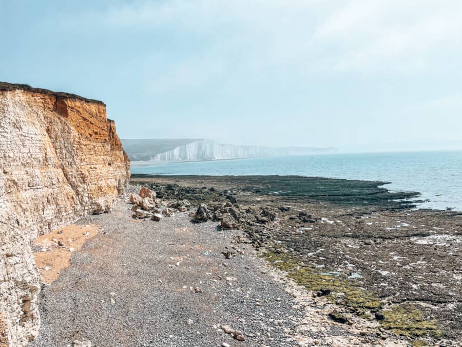 Standing at Hope Gap overlooking the incredible Seven Sisters Cliffs plunging into the ocean in the South Downs National Park, East Sussex