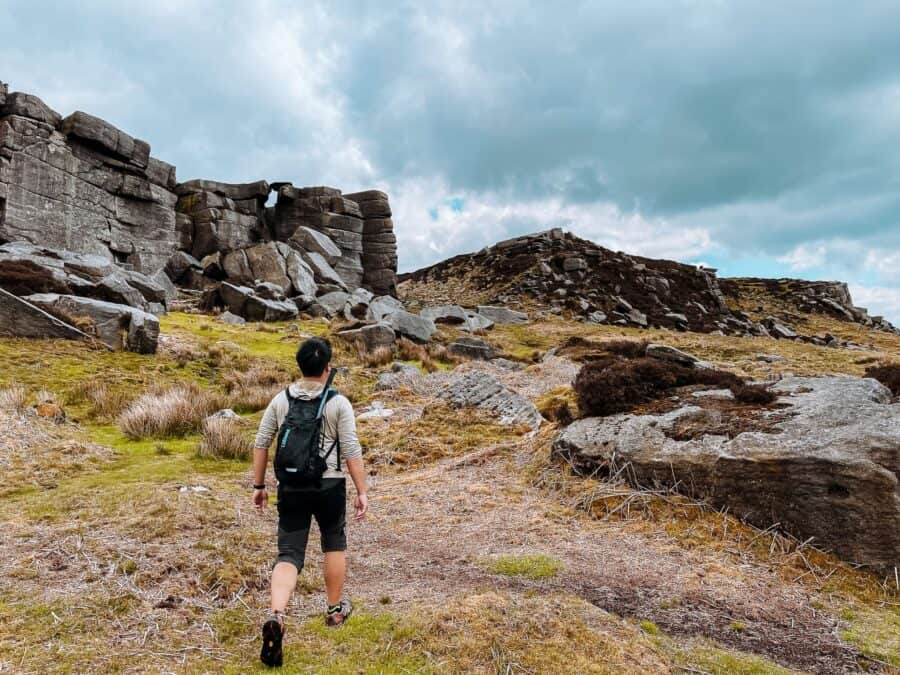 Andy hiking up to the huge gritstone of Stanage Edge, The Peak District