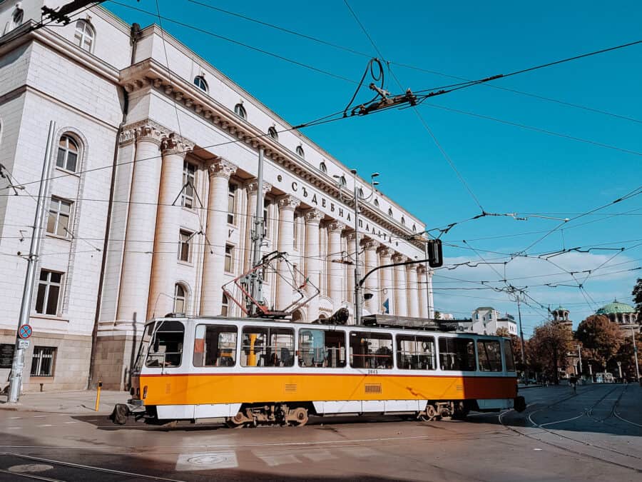 A bright yellow tram driving the streets of Sofia, Bulgaria