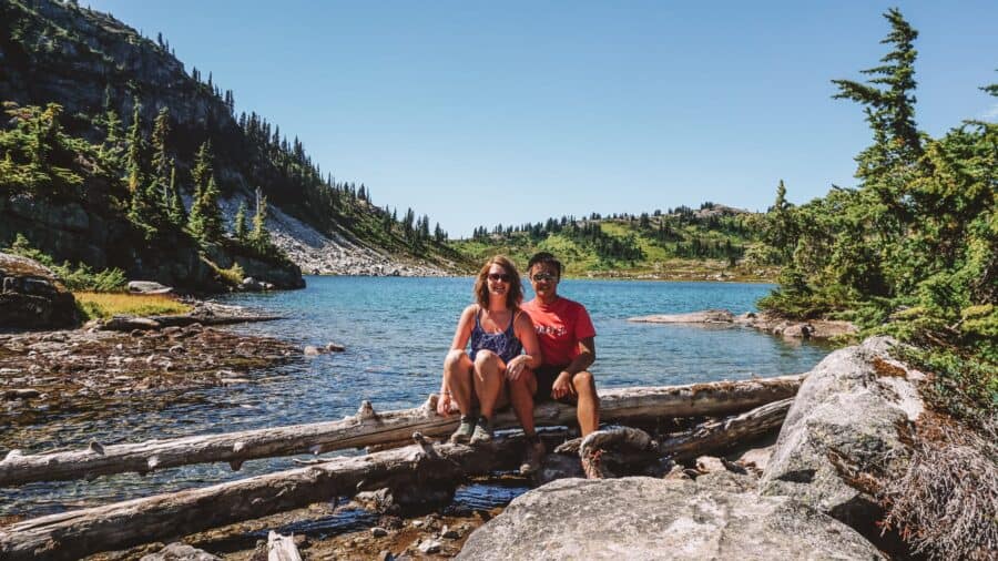 Andy and Helen sat on the shores of the pristine alpine Rainbow Lake is one of the most beautiful hikes in Whistler, Canada