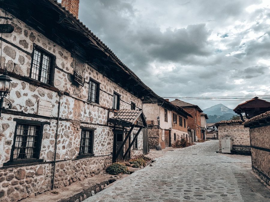 The quaint cobbled streets of Bansko Old Town with Mount Vihren looming in the distance, Bulgaria