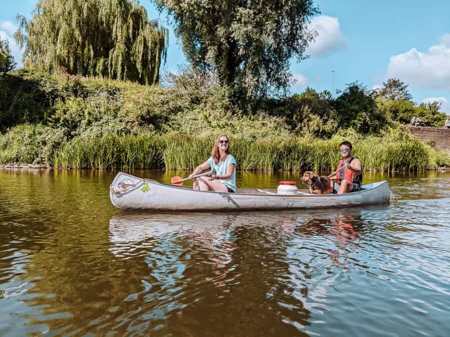 Andy, Helen and Plum in a canoe surrounded by greenery on the River Wye in the Wye Valley, Wales