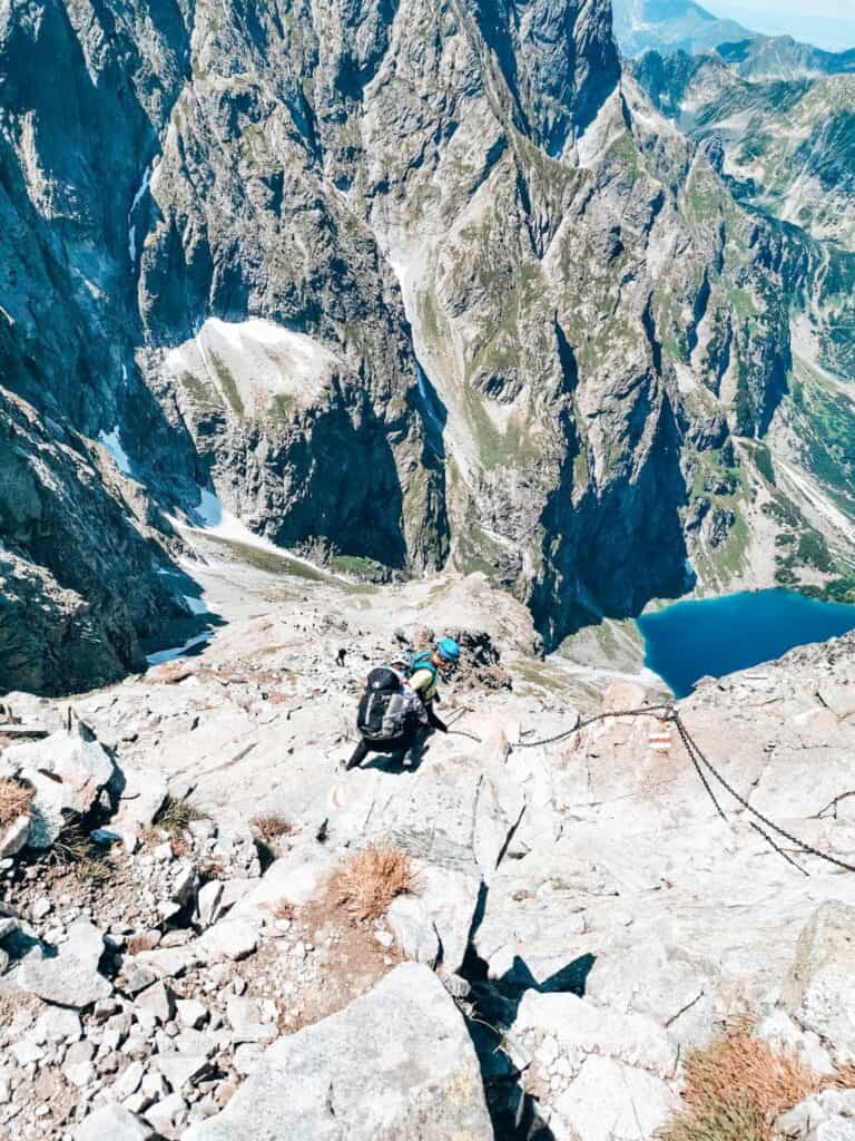 Using chains to hike up Rysy Peak with a view over Morskie Oko, Zakopane, Poland, Tatra Mountains