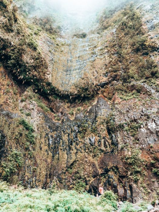 Helen sat at the bottom of colossal steep walls at Caldeirão Inferno, Madeira, Portugal