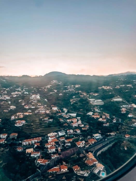 Houses nestled into the sides of mountains as you come into land in Madeira Airport, Portugal