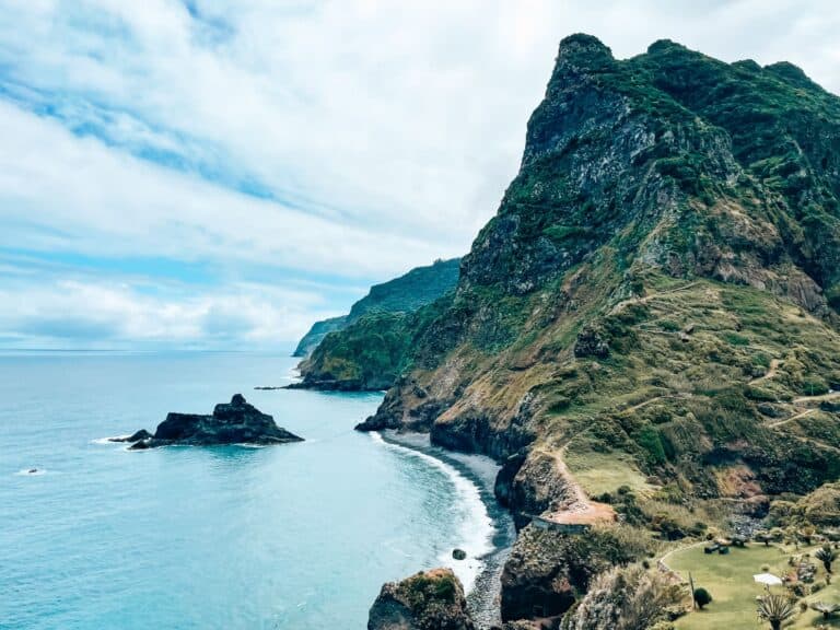 Steep sloping cliffs plunging into the ocean and the lush green interior at Miradouro de São Cristovão, Madeira, Portugal