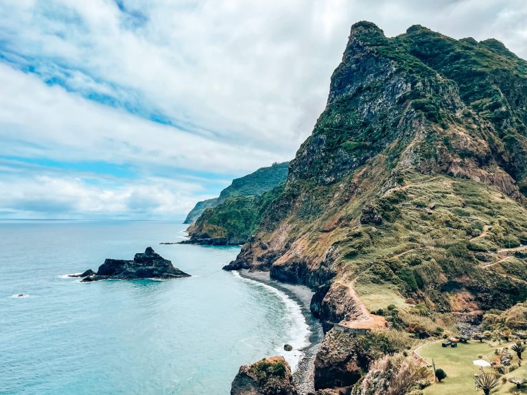 Steep sloping cliffs plunging into the ocean and the lush green interior at Miradouro de São Cristovão, Madeira, Portugal