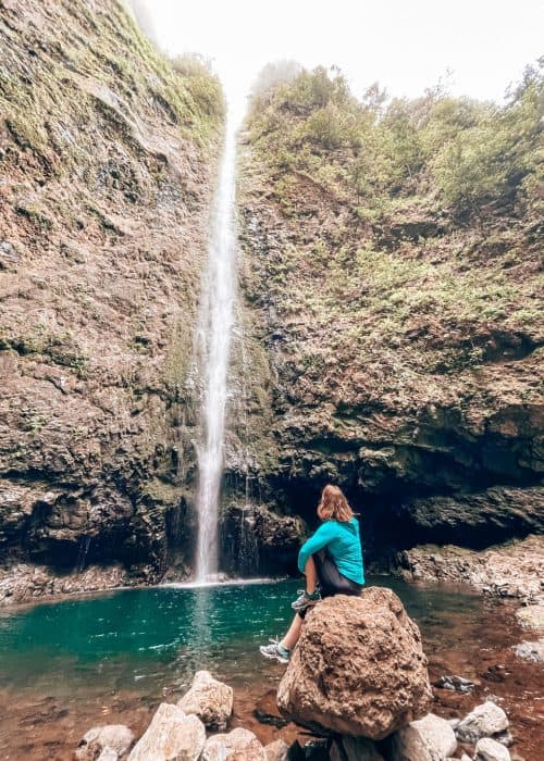 Helen sitting at the bottom of the Caldeirão Verde Waterfall, Madeira, Portugal