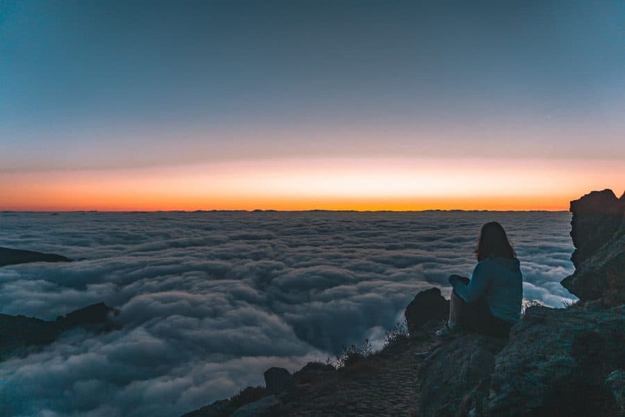 Helen sat at the Pico do Arieiro viewpoint at sunrise above the clouds, Madeira, Portugal