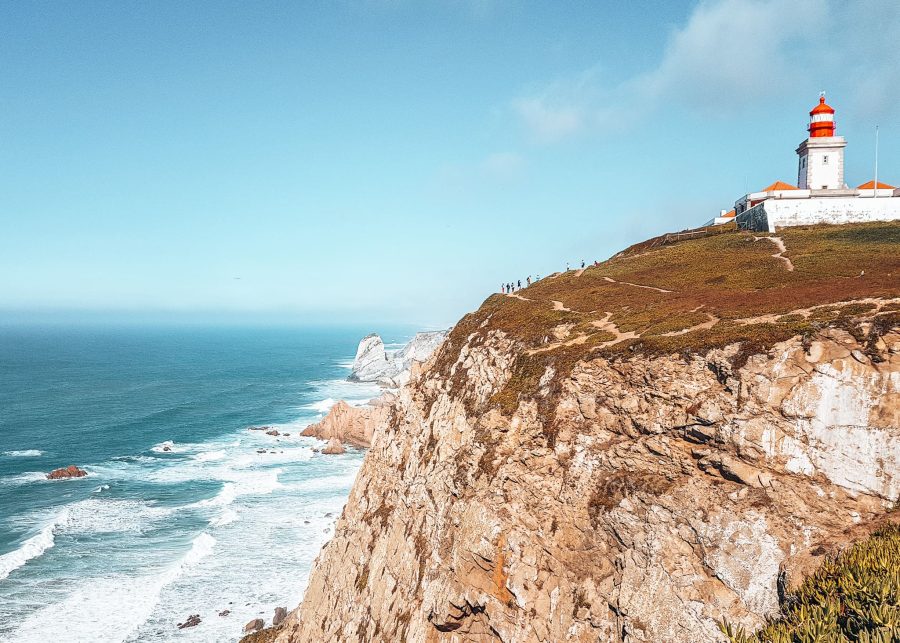 A pretty lighthouse stood on top of a cliff above the ocean at Cabo da Roca, day trips from Lisbon by train, Portugal