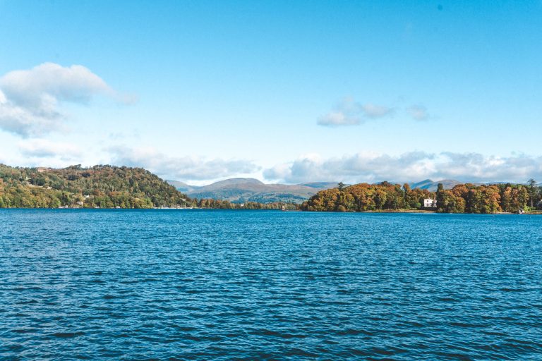 Clear blue skies and the calm Lake Windermere with dramatic mountains in the background, things to do in the Lake District National Park, England