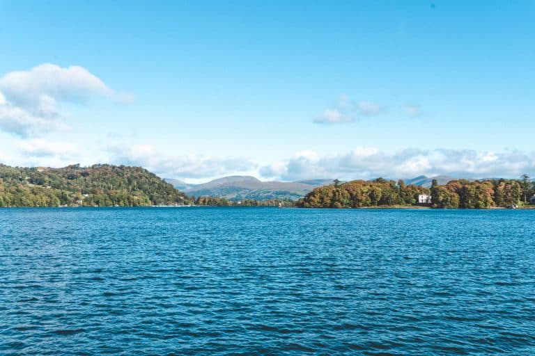 Clear blue skies and the calm Lake Windermere with dramatic mountains in the background, Lake District National Park, England