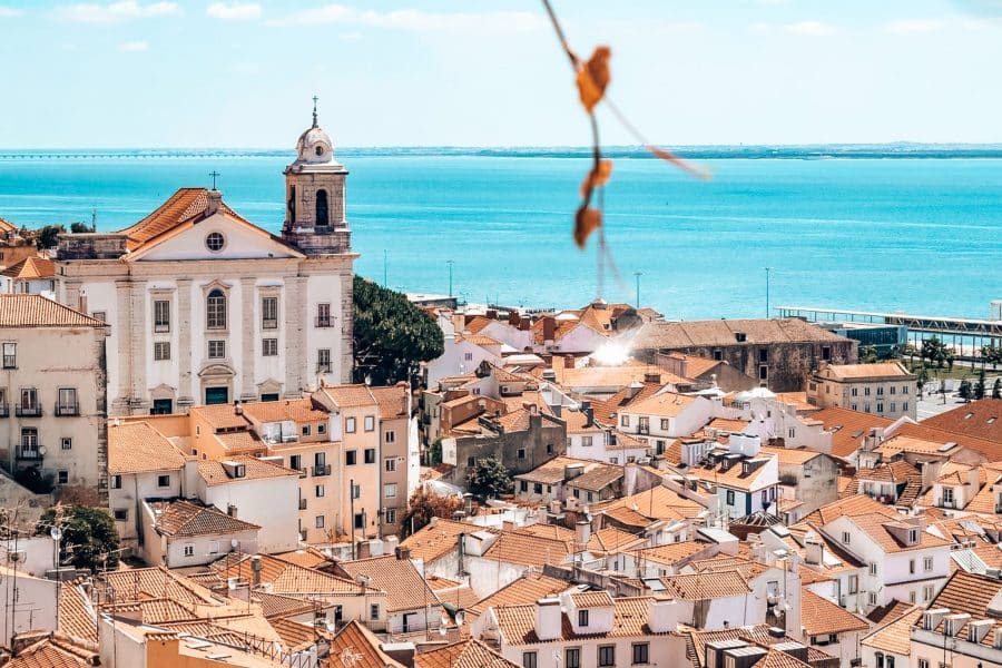 Viewpoint in Lisbon overlooking white-washed houses and red roofs out to the ocean, Lisbon, Portugal