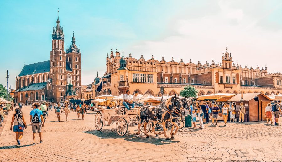 St Mary's Basilica, old architecture and a horse drawn carriage in Krakow Main Square, Poland