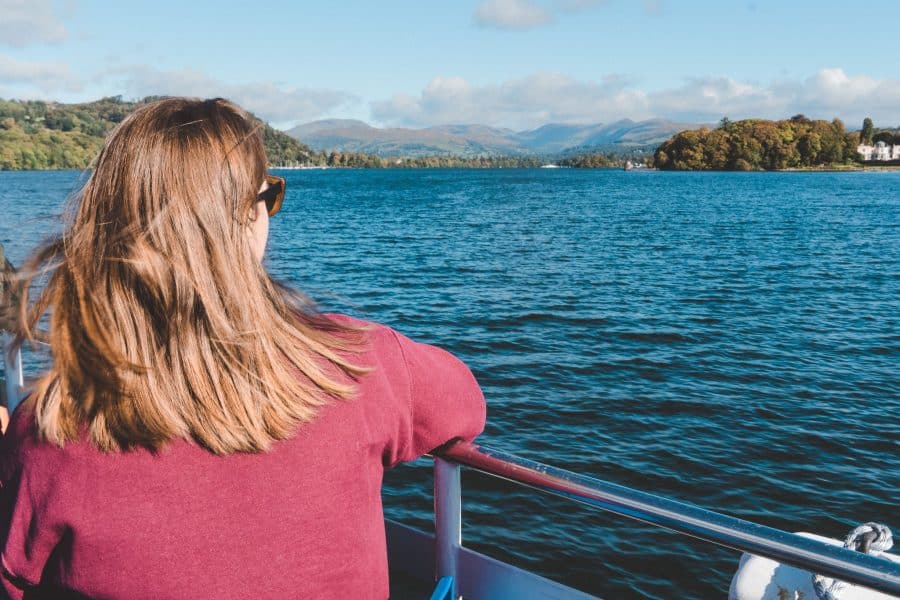 Helen sitting on the top deck of the boat on Lake Windermere admiring the beautiful scenery on our weekend in the Lake District, Bowness, England, UK
