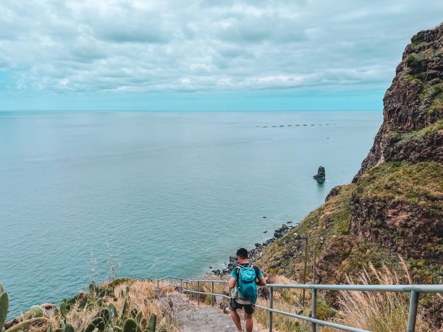Andy hiking down the steep slopes of the volcanic cliffs to Calhau da Lapa, hidden gems in Madeira, Portugal